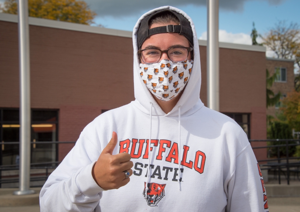 Buffalo State student wearing mask gives thumbs up sign