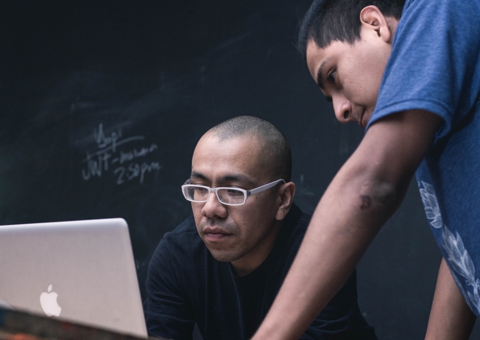 Teacher and student in front of a laptop